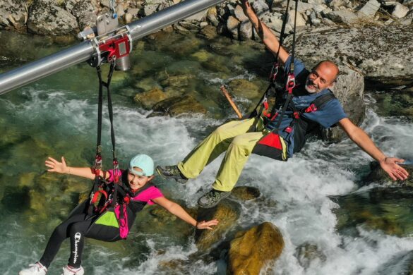 Zip Line Flying Fox with Centrifugal Brake Speed Control Two riders on a zip line (Flying Fox) over a rocky river, safely speed-limited by an Amsbeck centrifugal brake.